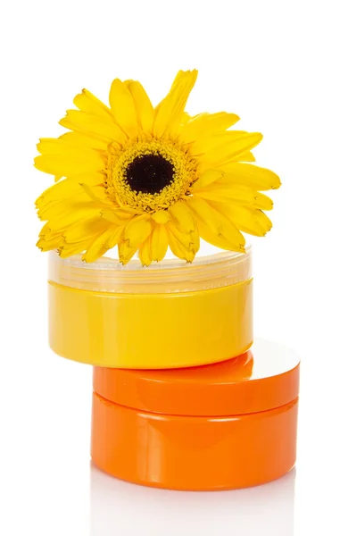 Containers van een verschillende cosmetische crèmes en bloem van gerbera, geïsoleerd op whit — Stockfoto
