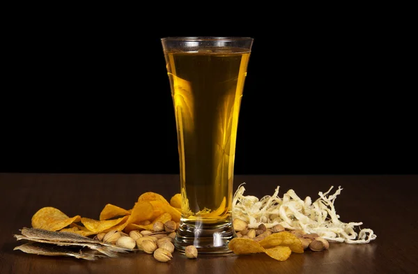 Glass of beer and the various snack, on the table — Stock Photo, Image