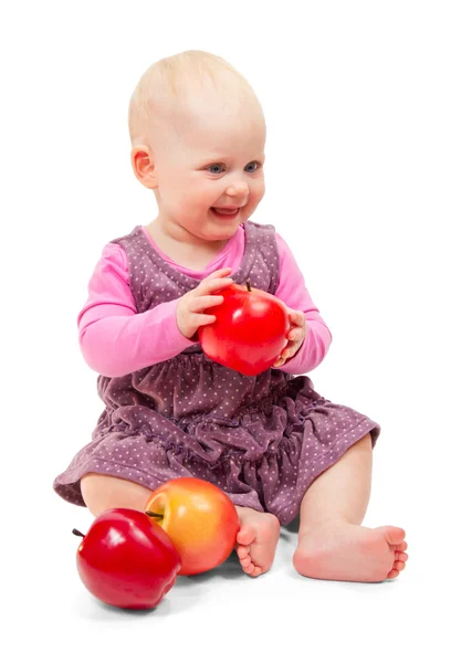 Mor elbise oturur ve elma neşeli tatlı bebek. beyaz izole — Stok fotoğraf