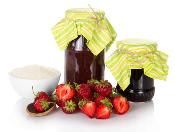 Jars of jam, cup with sugar, a heap the strawberries — Stock Photo, Image