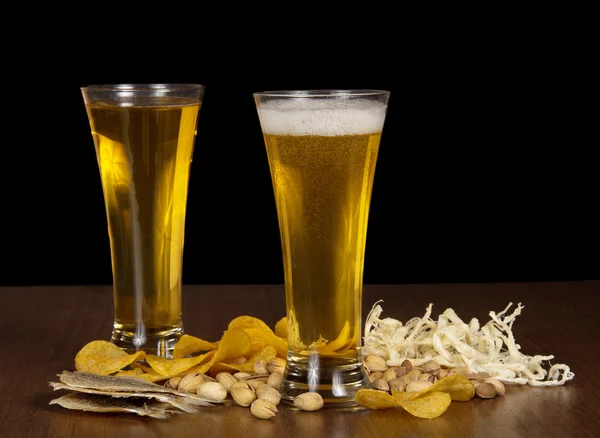 Szkło dwa piwa z pianki i fiolek, przekąskę do piwa, na stole — Zdjęcie stockowe