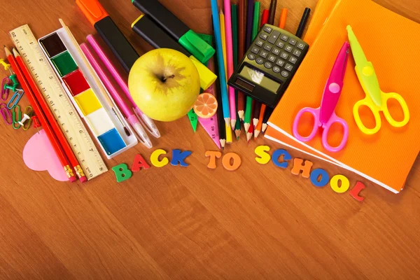 Exercise books, a big set of school tools the calculator and apple on a table — Stock Photo, Image