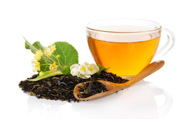 Tasse avec thé, feuilles de thé avec des bleuets, une fleur de jasmin et de tilleul, une cuillère en bois — Photo