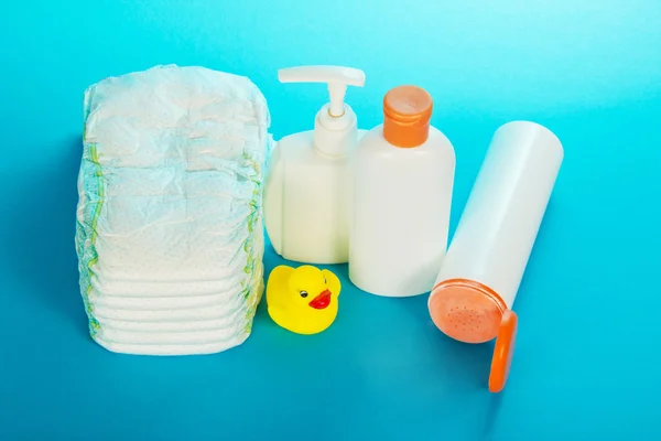 Baby cosmetics and diapers, on a blue background — Stock Photo, Image