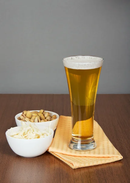 Bardak bira, Antep fıstığı, kurutulmuş kalamar ve peçete — Stok fotoğraf
