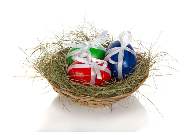 Easter eggs with ribbons in a nest, isolated on white — Stock Photo, Image