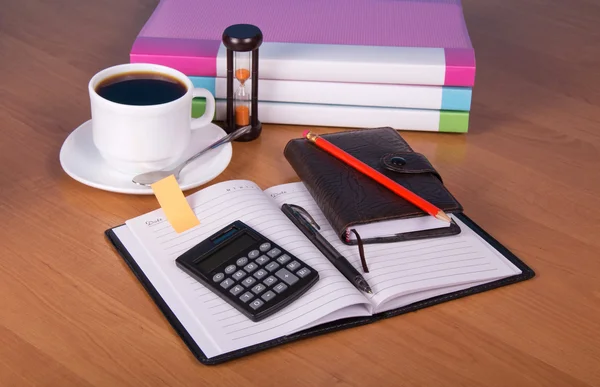 Notepad, organizer, folders for documents the calculator, hourglasses and a cup of coffee on a table — Stock Photo, Image