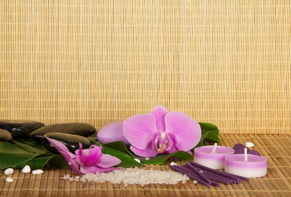 Flores de una orquídea y conjunto para Spa en un paño de bambú. Fondo beige Imagen De Stock