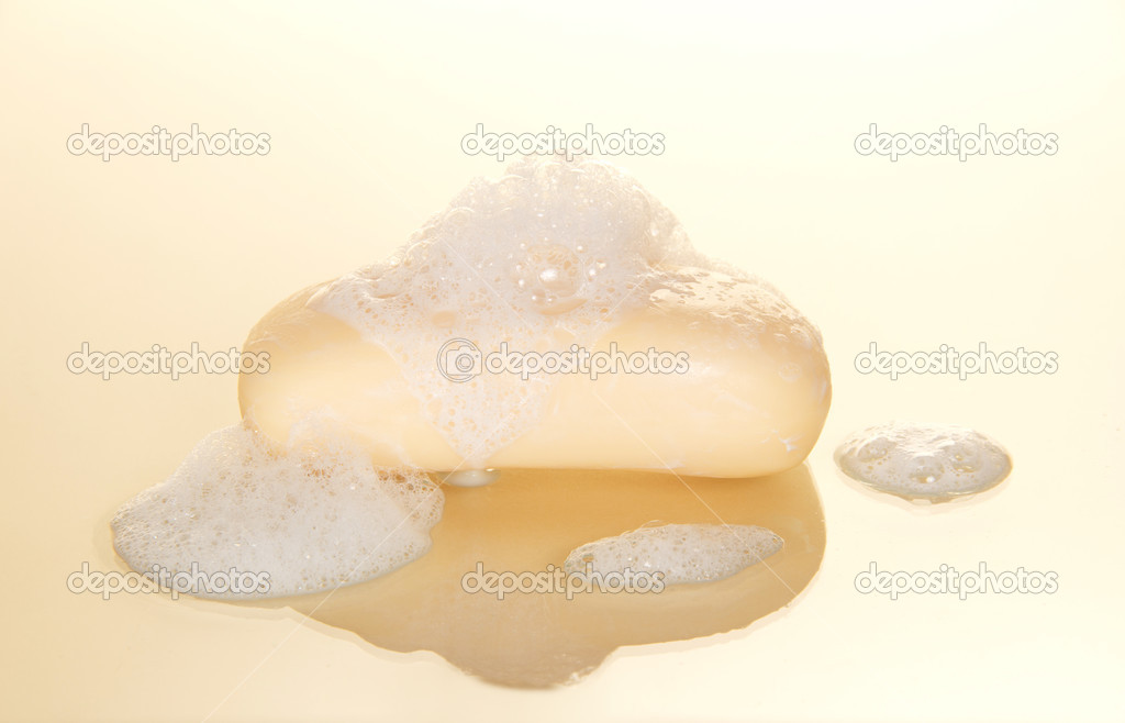 Wet bar of soap on a beige background