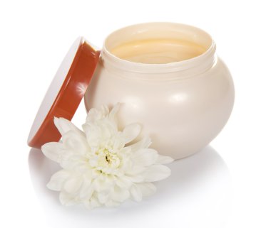 kavanoz kozmetik krem ve beyaz izole çiçek ile açın.