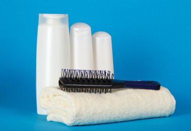 saç fırçası terry havlu ve bir kozmetik bir duş için mavi bir arka plan ayarla
