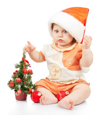Noel ağacı üzerinde beyaz izole yakınındaki santa şapkalı güzel bebek