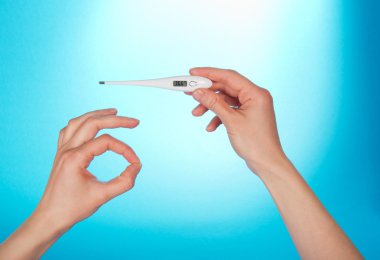 Elektronik termometre ile mavi bir arka plan üzerinde normal sıcaklık