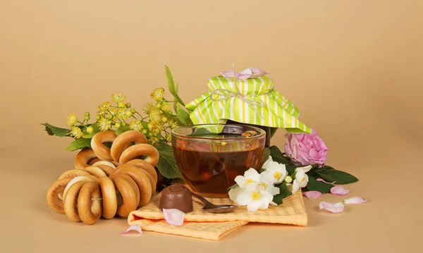 Kopje thee, hoop bagels, chocolade en bloemen — Stockfoto