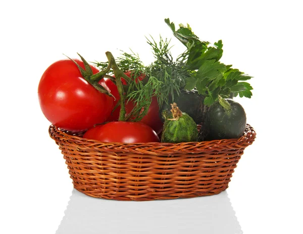 Cucumbers, tomatoes and greens in the wicker basket — Stock Photo, Image