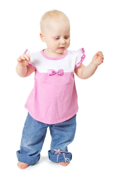 De mooie kleine baby in roze jas en blue jeans. geïsoleerd op wit — Stockfoto