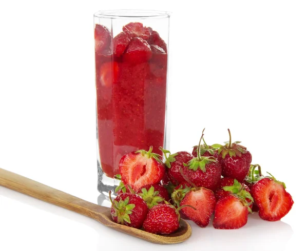 Fraise dans un verre, une colline de fraises à proximité et des baies dans la cuillère en bois — Photo