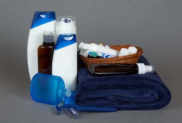 The razor, lotion, cosmetics set in a basket and a towel on a gray background — Stock Photo, Image