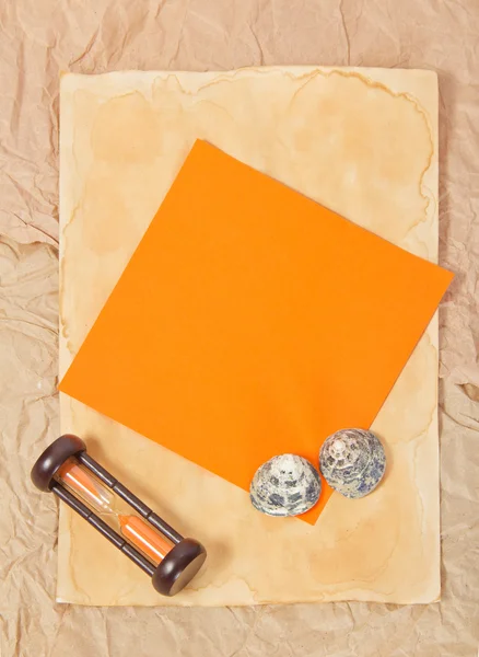 Kertas tua, dua kerang laut, jam pasir dan kartu oranye — Stok Foto