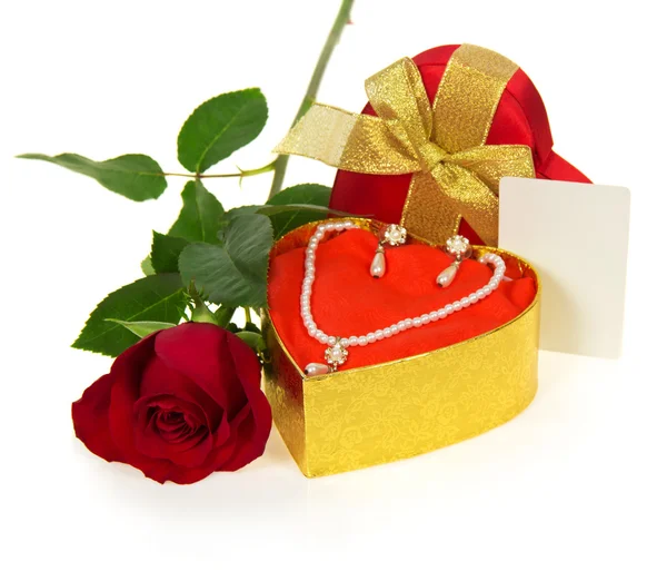Ожерелье и серьги в золотой подарочной коробке с алой розой и открыткой для поздравления изолированы на белом — стоковое фото