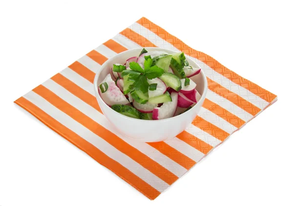 Tigela com salada no guardanapo listrado brilhante, isolado em branco — Fotografia de Stock
