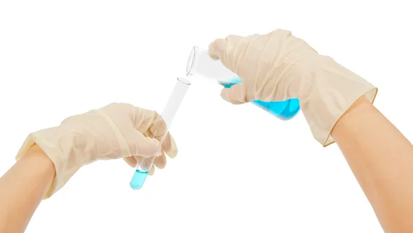 Laboratóriumi üvegeszközök kék folyadékkal, elszigetelt fehér kesztyűt kezét — Stock Fotó