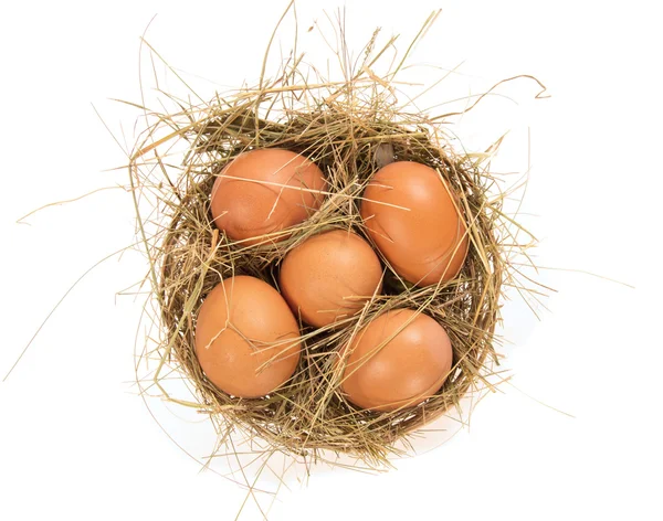 Eggs, hay in a bast basket, isolated on white — Stock Photo, Image