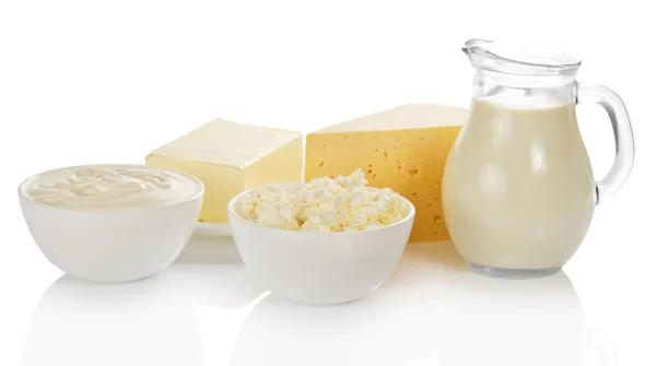 Молоко, миска с творогом и сметаной, сыр и масло на тарелке, изолированной на белом — стоковое фото