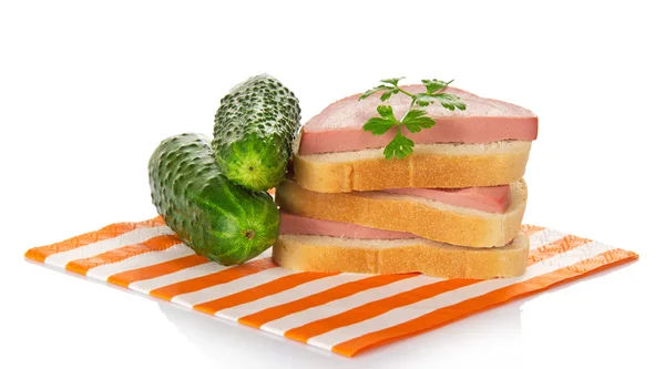 Sandwiches mit Wurst, Petersilie und grünen Gurken auf einer gestreiften Serviette — Stockfoto