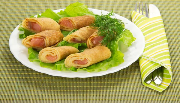 Pannenkoeken met zalm en salade, bestek op bamboe servet — Stockfoto