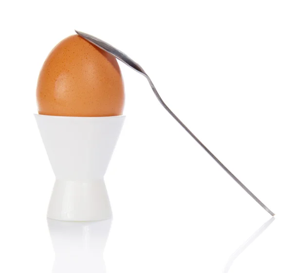 Egg in a support and a teaspoon, isolated on white — Zdjęcie stockowe