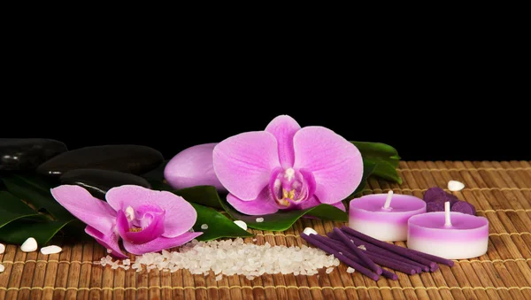 Flores de orquídea, conjunto para Spa en el paño de bambú, aislado en negro —  Fotos de Stock