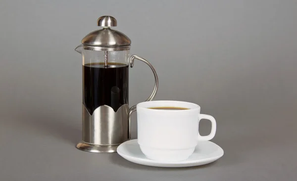 कॉफी निर्माता आणि राखाडी पार्श्वभूमीवर सुगंधी कॉफीचा कप — स्टॉक फोटो, इमेज