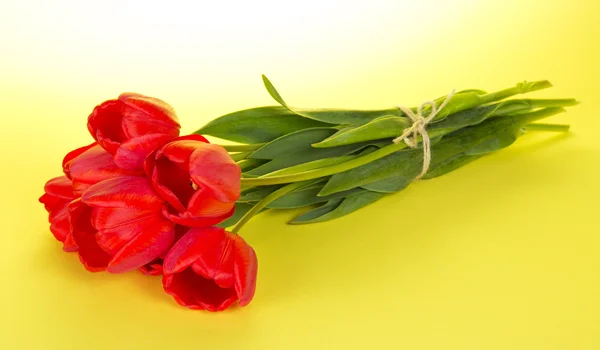 Boeket van tulpen met een touw, op een gele achtergrond — Stockfoto