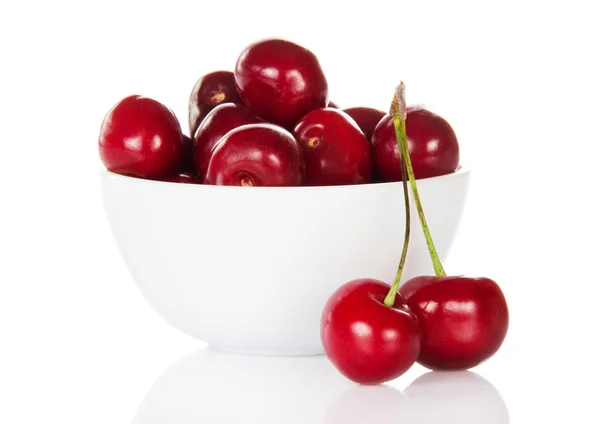 Cerises douces rouges dans une tasse et deux baies près — Photo