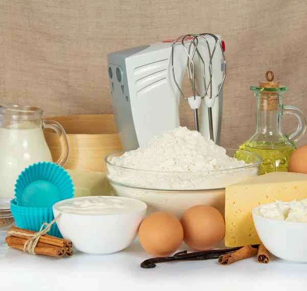 Set producten voor het bakken, een mixer en een taart pan tegen een doek — Stockfoto