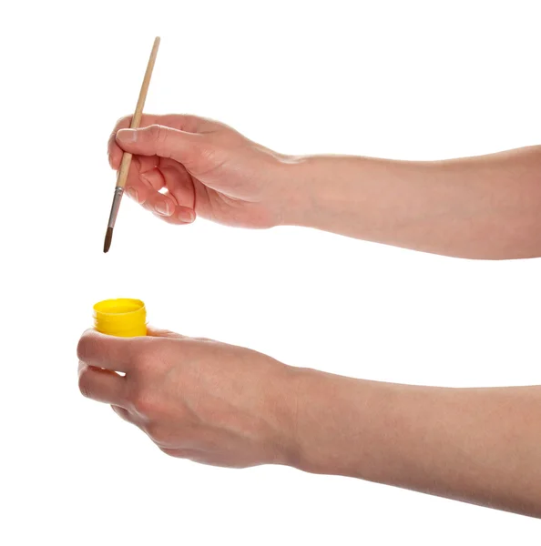 As mãos seguram uma escova e a pintura amarela, isolada no branco — Fotografia de Stock