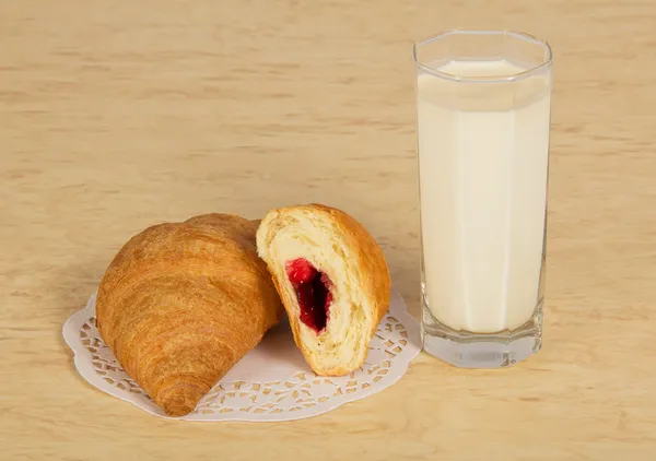 Glas met melk en croissants, een servet, op een tafel — Stockfoto