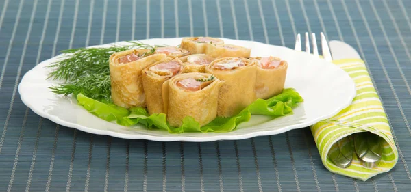 Pannenkoeken met zalm en salade op bamboe servet — Stockfoto