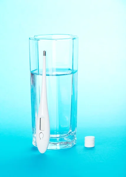 Kaca dengan air, tablet dan termometer — Stok Foto