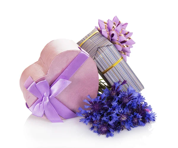 Le scatole regalo decorate con un nastro e un fiocco, e il bouquet dei fiordalisi — Foto Stock