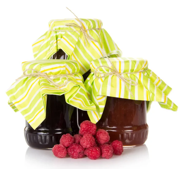 Pots de confiture et une poignée de framboises mûres, isolés sur blanc — Photo