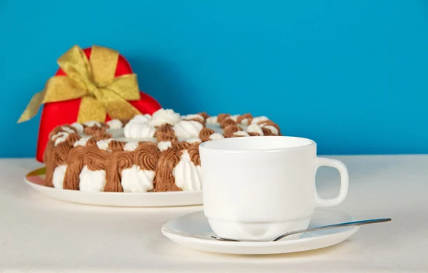 Чай, подарок и пирог на белом полотне, на синем фоне — стоковое фото