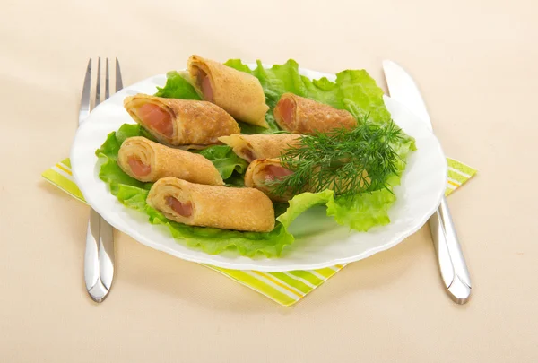 Pannenkoeken met zalm en salade, bestek, kleurrijke servet op gele tafellaken — Stockfoto