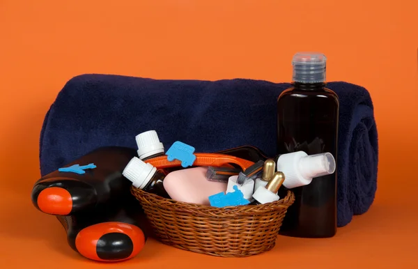 Big terry towel and basket with cosmetics on an orange background — Stock Photo, Image