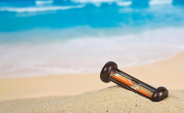 Reloj de arena en una playa de arena —  Fotos de Stock