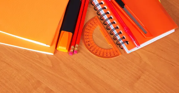 Füzet, Jegyzettömb, toll, ceruza, marker, vágó és szögmérő egy asztal — Stock Fotó