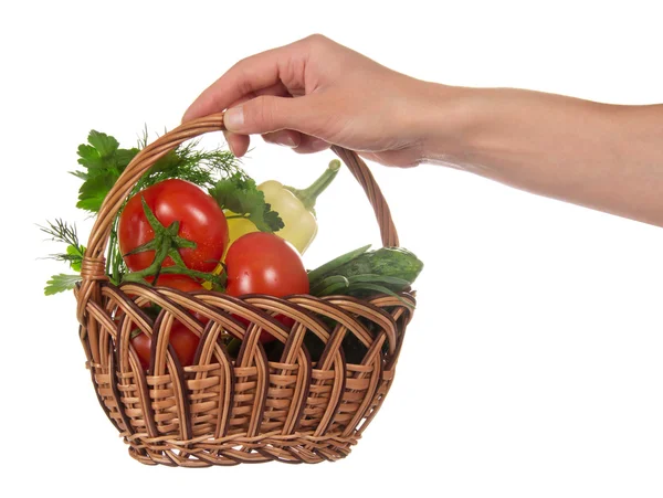 La mano femminile tiene un cesto con le verdure, isolato su bianco — Foto Stock