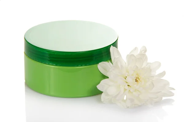 Косметический крем в зеленом контейнере и цветок изолированы на белом — стоковое фото
