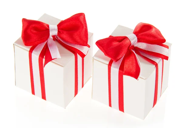 Dos cajas de regalo blancas con un lazo rojo y la cinta, aisladas en blanco — Foto de Stock